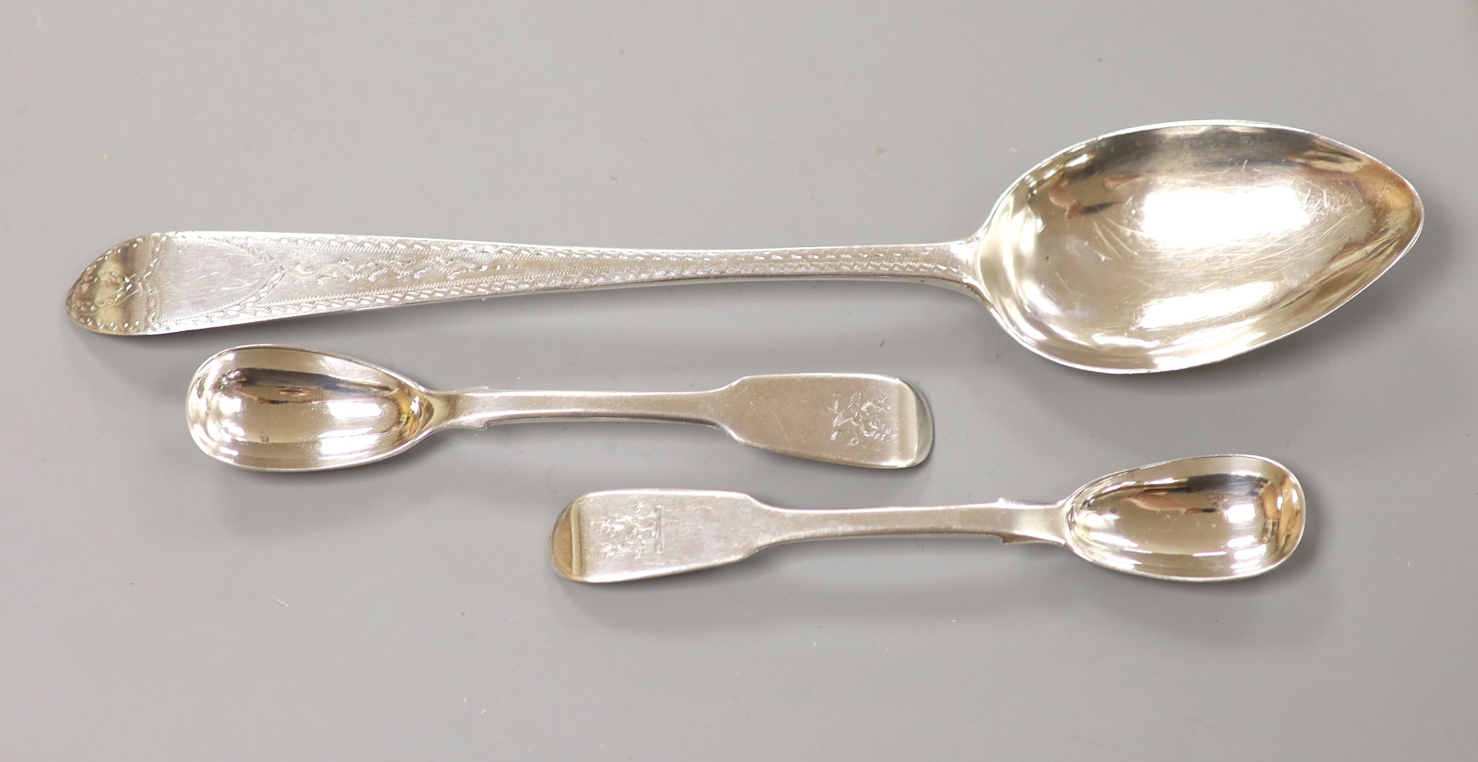 A George III Irish bright cut engraved silver tablespoon, John Shiels, Dublin, 1765 and two Victorian silver mustard spoons, 83 grams.